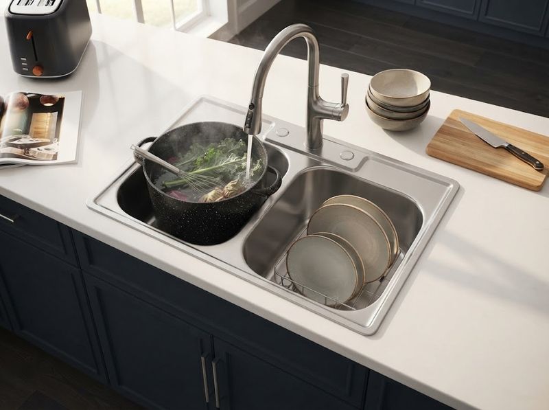 Stainless double-bowl sink in an open-plan kitchen at night